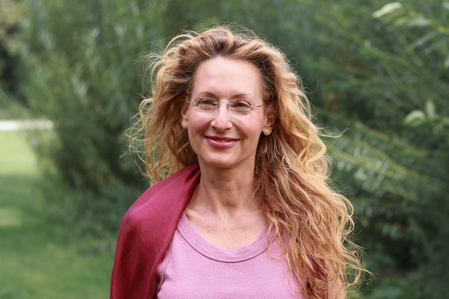 Portrait von Uta Susanne Lowack vor grünem Blattwerk